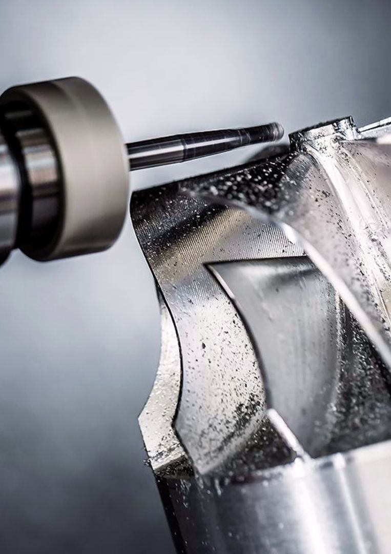 CNC-Fräsvorgang an einem komplexen Metallbauteil mit hoher Oberflächenqualität - Beispiel für präzise Zerspanungstechnik.